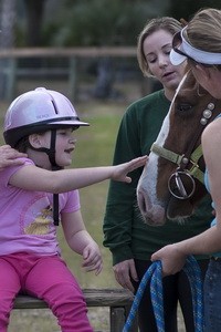 hippotherapy client petting horse